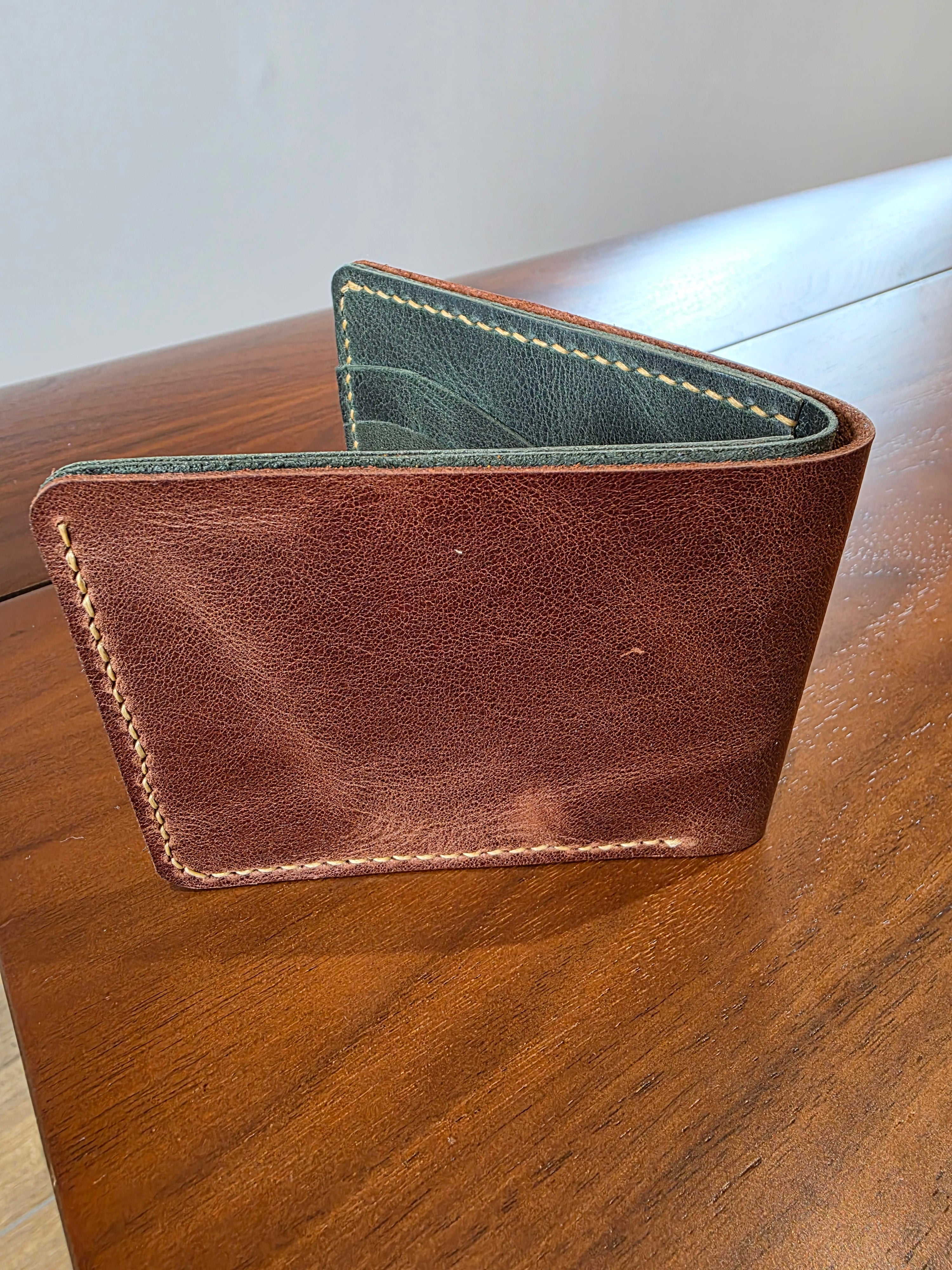 Geldbeutel aus Rindsleder außen in Braun- innen Grün gehalten. Handgenäht