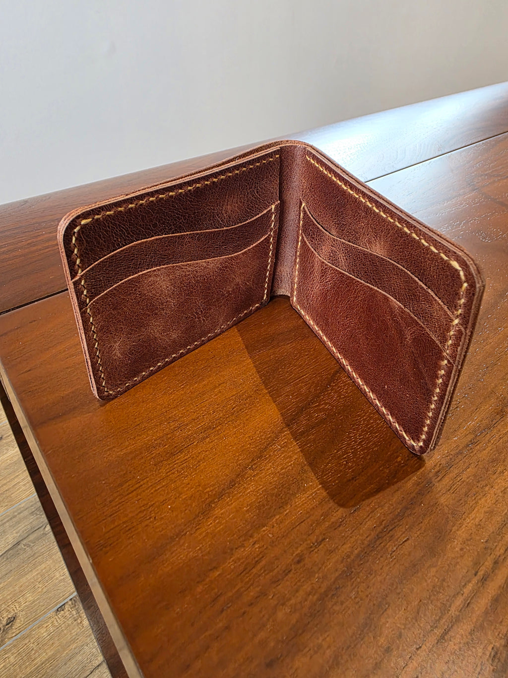 Geldbeutel aus Rindsleder in Braun gehalten. Handgenäht